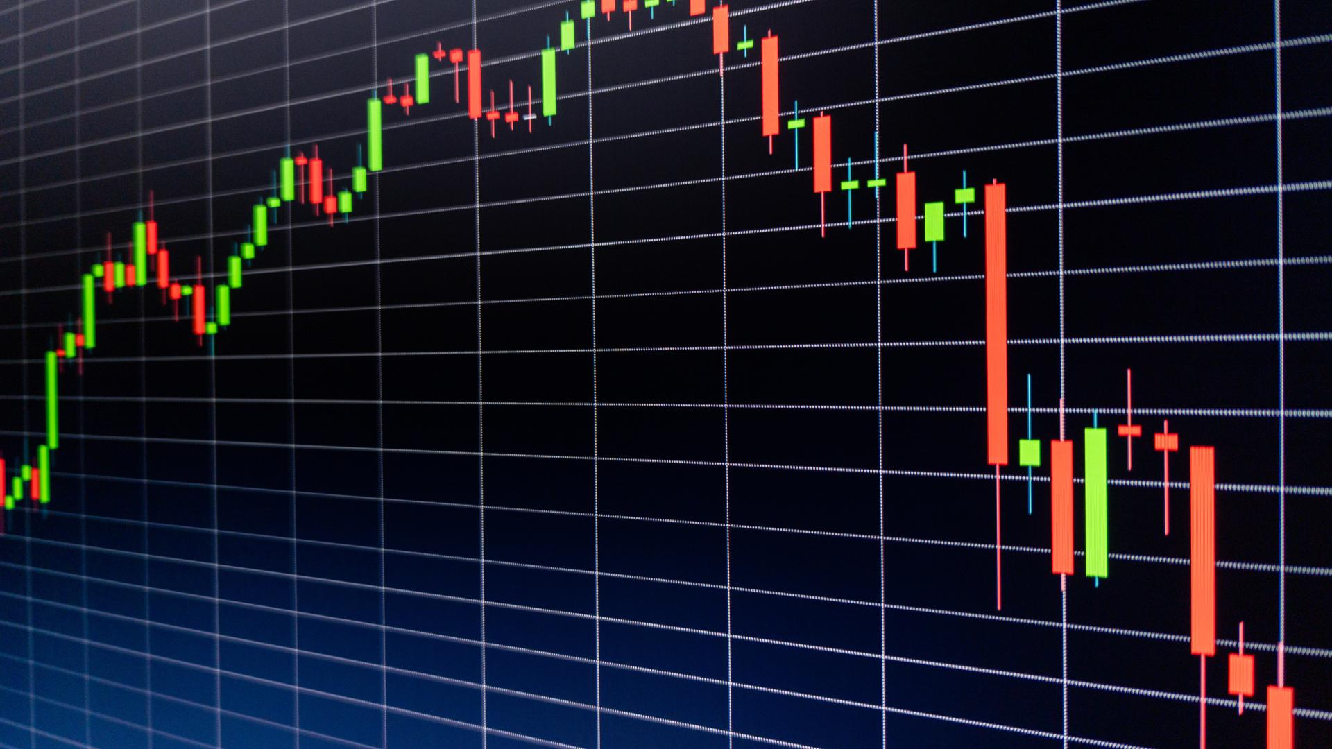 Close-up of a dark digital trading screen showing a green-and-red candlestick chart that climbs steadily, peaks, then reverses into a sustained red decline, overlaid with a perspective grid.